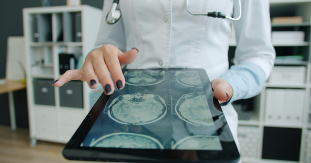 Medical professional reviewing digital x-rays on a tablet, showcasing artificial intelligence search and analysis optimization in the medical field.