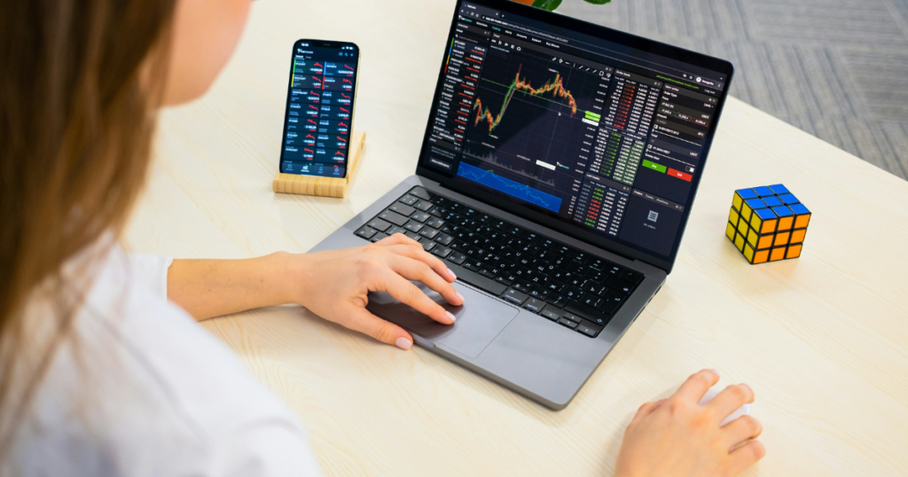 A woman who looks like a trader is using her laptop for trading purposes.